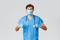 Healthcare workers, coronavirus quarantine campaign and pandemic concept. Cheerful doctor in scrubs, medical mask and