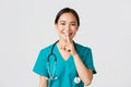 Healthcare workers, preventing virus, quarantine campaign concept. Smiling pretty asian doctor, nurse in scrubs smiling Royalty Free Stock Photo