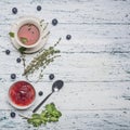 Healthful autumn hot herbal tea with berries, thyme and mint, jam from a rose, a spoon, cut lemon, on a rustic wooden background