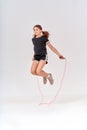 Healthy and active. Full-length shot of a cute teenage girl skipping with a jump rope  over grey background in Royalty Free Stock Photo