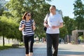 Middle-aged couple in sportswear walking and talking in the park Royalty Free Stock Photo