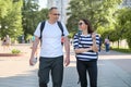 Middle-aged couple in sportswear walking and talking in the park Royalty Free Stock Photo