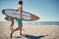 Healthy Active Lifestyle. Surfing. Summer Vacation. Extreme Sport. Young surfer man walking with board on the sandy beach. .