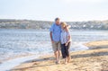 Healthy active senior couple holding hands, embracing each other and walking on beach Royalty Free Stock Photo