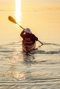 Healthy, active senior man sea kayaking at sunrise or sunset. Outdoor adventure water sports enjoying secure, independent