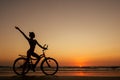 Healthy alone woman ride on bicycle on empty sunset Goa India beach