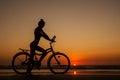 Healthy alone woman ride on bicycle on empty sunset Goa India beach