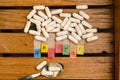 Healthy alphabet and capsule drug and spoon on wood background