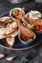 Healthy appetizer or snack with hummus, cod liver with ricotta, guacamole, rabbit sirloin, eggplant caviar in bowls over grey back