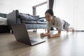 Healthy asian child girl is doing plank exercise and push up,strong fitness girl watch live workout online on laptop computer, Royalty Free Stock Photo