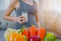 The healthy Asian pregnant young woman with a glass of milk and with many kinds of fruit and vegetable
