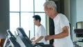 Healthy Asian senior couple exercise together in gym running treadmill Royalty Free Stock Photo