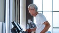Healthy Asian senior couple exercise together in gym running treadmill Royalty Free Stock Photo