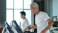 Healthy Asian senior couple exercise together in gym running treadmill Royalty Free Stock Photo