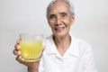 Healthy asian senior grandmother drinking a glass of vitamin C or orange juice,elderly people with effervescent vitamin C, Royalty Free Stock Photo