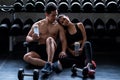 Happy couple relax after exercise in gym