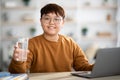 Healthy asian teenager holding glass of water while studying Royalty Free Stock Photo