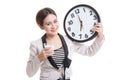 Healthy Asian woman drinking glass of milk hold clock. Royalty Free Stock Photo