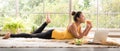 Healthy Asian woman lying on the floor eating salad looking relaxed and comfortable Royalty Free Stock Photo