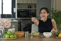 Healthy woman sitting at home kitchen and enjoying her vegan meal. Diet and Healthy food concept. Royalty Free Stock Photo