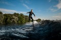 healthy man balancing on hydrofoil foilboard on wave on sunny day