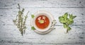 Healthy autumn hot herbal tea with berries, thyme on white wooden rustic background