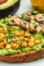 Healthy avocado toasts with chickpeas and mushrooms on a light background, vegetarian vegan food. vertical image. top view. place