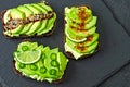 Healthy avocado toasts with spices, lime and chili, presented on a gray stone board. Royalty Free Stock Photo