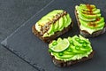 Healthy avocado toasts with spices, lime and chili, presented on a gray stone board. Royalty Free Stock Photo