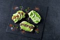 Healthy avocado toasts with spices, lime and chili, presented on a gray stone board. Royalty Free Stock Photo