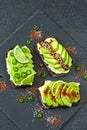 Healthy avocado toasts with spices, lime and chili, presented on a gray stone board. Royalty Free Stock Photo