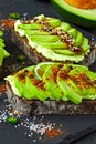 Healthy avocado toasts with spices, lime and chili, presented on a gray stone board. Royalty Free Stock Photo