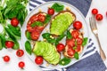 Healthy avocado and tomatoes sandwiches with hummus, sesame and basil in a plate with towel and fork Royalty Free Stock Photo