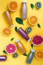 Healthy background with different juices and fruits on yellow desk.