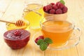 healthy background. raspberry with raspberry jam, honey and tea on light wooden background