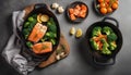 Healthy baked fish salmon steaks, broccoli, cauliflower, carrot in black cast iron casserole bowl