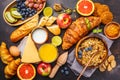 Healthy balanced breakfast on a dark background. Muesli, milk, juice, croissants, cheese, biscuits Royalty Free Stock Photo