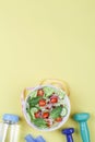 Healthy balanced diet concept, fresh salad with cucumbers tomato, measuring tape, dumbbell, bottle of water Royalty Free Stock Photo