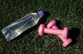 healthy balanced lifestyle. maintain water balance in body while training. barbells and bottle on green grass. sport