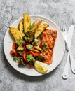 Healthy balanced lunch - grilled salmon, baked ratatouille and potatoes on a gray background, top view