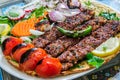 Healthy barbecue different meat with vegetables and sauce. served with a black plate. close up view on a light background. Arabic Royalty Free Stock Photo