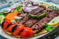 Healthy barbecue different meat with vegetables and sauce. served with a black plate. close up view on a light background. Arabic Royalty Free Stock Photo