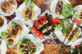 Healthy barbecued lean cubed pork kebabs served with a corn tortilla and fresh lettuce and tomato salad, close up view Royalty Free Stock Photo