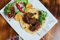 Healthy barbecued lean cubed pork kebabs served with a corn tortilla and fresh lettuce and tomato salad, close up view Royalty Free Stock Photo