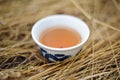 Healthy beverage. Black tea in Chinese bowl in dry grass