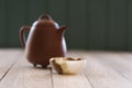 Healthy beverage concept. Chinese teaware: clay pot and onyx stone cup on white wooden table copy space. Minimalist style still