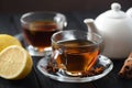 Healthy beverage. Spicy black tea in glass cup with lemon, cinnamon and star anise on black background Royalty Free Stock Photo