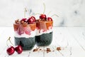 Healthy Black Forest dessert. Black activated charcoal chia pudding with cherries, coconut cream and chocolate. Vegan breakfast
