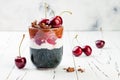 Healthy Black Forest dessert. Black activated charcoal chia pudding with cherries, coconut cream and chocolate. Vegan breakfast Royalty Free Stock Photo