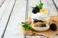 Blackberry and banana yogurt parfait in a mason jar on rustic white wood